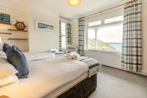 two beds in a bedroom with a large window at 6 Bed in Mortehoe oc-hillcr in Mortehoe