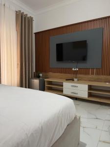 a bedroom with a bed and a television on a wall at Vila JONI in Berat