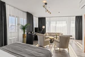 a bedroom with a bed and chairs and a desk at Unique Boutique in Bucharest