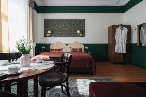 a hotel room with a bed and a table and chairs at Willa Pałacyk in Świeradów-Zdrój