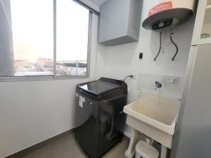 a small kitchen with a sink and a washer at Acogedor Refugio en Tacna in Tacna