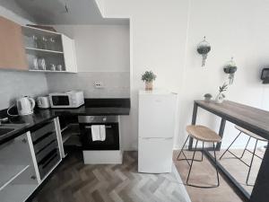 a kitchen with a white refrigerator and a table at Edinburgh Cozy Apartment in Edinburgh