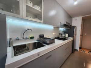 a kitchen with a sink and a refrigerator at Acogedor Refugio en Tacna in Tacna