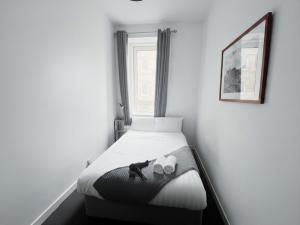 a small bedroom with a bed with two cups and a picture at Edinburgh Cozy Apartment in Edinburgh