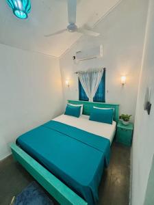 a bedroom with a blue and white bed and a window at Casa Meraki in Dickwella