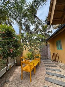 a row of wooden benches sitting next to a building at Casa Meraki in Dickwella