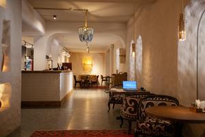 a restaurant with tables and chairs and a laptop on a table at By Tau in Almaty