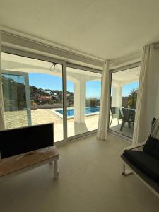 a living room with a view of a swimming pool at Villa Bouganvilla Parking privado 32 en la playa in Tossa de Mar