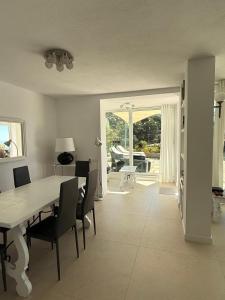 a living room with a table and chairs and a dining room at Villa Bouganvilla Parking privado 32 en la playa in Tossa de Mar