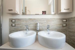 two sinks in a bathroom with two mirrors at L'Ulivo bed and breakfast in Decima +17 photos