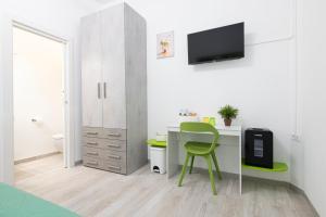 a small room with a desk and a green chair at L'Ulivo bed and breakfast in Decima