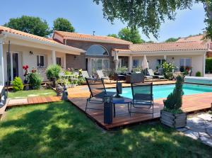 a backyard with a wooden deck and a swimming pool at La Clef Des Anges 2 Chambres in Égliseneuve-près-Billom