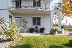 a white house with a balcony and plants at L'Ulivo bed and breakfast in Decima
