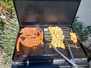 a grill with some meat and vegetables on it at La Clef Des Anges 2 Chambres in Égliseneuve-près-Billom