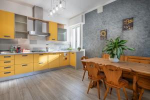 a kitchen with yellow cabinets and a wooden table at L'Ulivo bed and breakfast in Decima