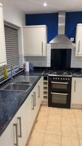 a kitchen with a sink and a stove top oven at PLUS Properties Oxford 1 in Stoke on Trent