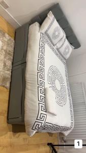 a bed with two pillows sitting next to a cabinet at PLUS Properties Oxford 1 in Stoke on Trent