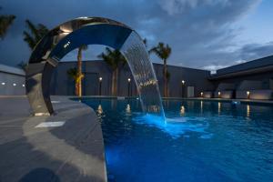 a water fountain in a pool at night at Hotel Art Village in Casoria