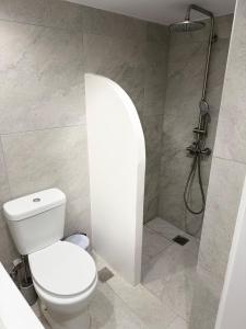 a bathroom with a white toilet and a shower at Little Gem -A Cycladic Aura- Serifos in Serifos Chora
