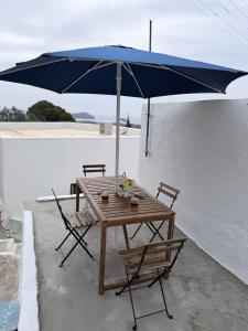 a wooden table and chairs with an umbrella at Little Gem -A Cycladic Aura- Serifos in Serifos Chora