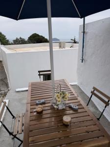 a wooden table with an umbrella on a balcony at Little Gem -A Cycladic Aura- Serifos in Serifos Chora