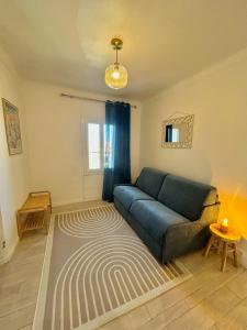 a living room with a blue couch and a rug at Hôtel Le Clos du Dramont in Saint-Raphaël