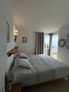 a white bedroom with a bed and a window at Villa Bouganvilla Parking privado 32 en la playa in Tossa de Mar +29 photos