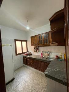 a kitchen with wooden cabinets and a white refrigerator at Appartement Belle vue 3 Meknès in Meknès