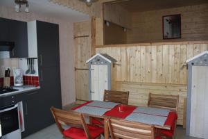 a dining room with a table and chairs in a kitchen at les pins in Quend