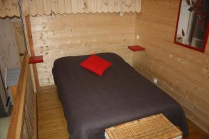 a small bedroom with a bed with a red pillow at les pins in Quend