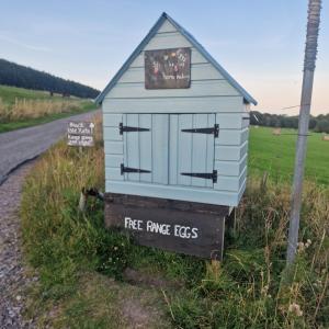 a dog house on the side of a road at Pleasant Point Holiday Cottages in Glenurguhart +17 photos