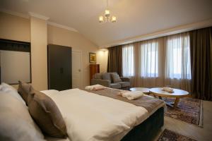 a bedroom with a large bed and a living room at By Tau in Almaty