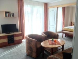 uma sala de estar com duas cadeiras, uma mesa e uma televisão em Villa Rügen em Ostseebad Sellin