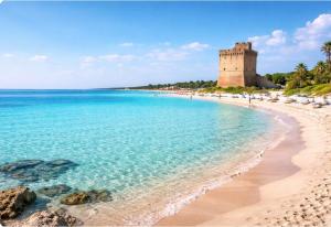 a view of a beach with a castle in the background at Villa Florence apartment con parcheggio in Torre Lapillo