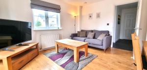 a living room with a couch and a table at Spacious 4 Bedroom House, Old Town in Swindon