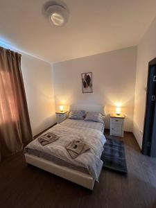a bedroom with a bed and two lamps on two tables at Matei's Apartment by the Sea in Constanţa