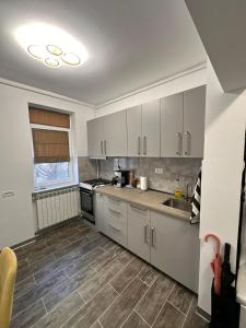 a kitchen with white cabinets and a sink at Matei's Apartment by the Sea in Constanţa