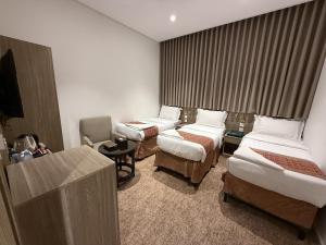 a hotel room with two beds and a television at Retaj Al Noor Hotel, فندق ريتاج النور in Medina