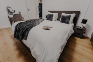a bedroom with a large white bed with two books on it at Lumea Noir - Designer Apartment in Timișoara in Timişoara