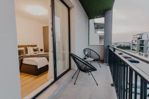a room with a balcony with a bed and a bedroom at Lumea Noir - Designer Apartment in Timișoara in Timişoara +31 photos