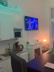 a kitchen with a fireplace and a tv on the wall at Urban Pair Luxe Suites in Vantaa