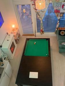a living room with a pool table in a room at Urban Pair Luxe Suites in Vantaa