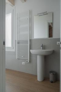 a white bathroom with a sink and a mirror at LaVero Maison in Castelfranco Emilia