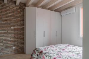 a bedroom with a bed and a brick wall at LaVero Maison in Castelfranco Emilia