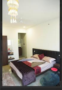 a bedroom with a large bed and a chandelier at rajapalace in Zahirābād