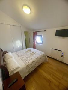 a bedroom with a bed with white sheets and a window at Corrubedo Beach Lodge in Corrubedo