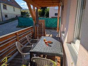 a table and chairs on the balcony of a house at Gîtes Marschall Jean-Pierre in Beblenheim