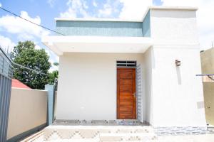 a white house with a wooden door at Be Home Apartments in Nkoanrua