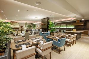 a restaurant with wooden tables and chairs and plants at The Westin Panama in Panama City
