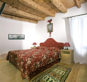 a bedroom with a bed with a red bedspread at B&B Gastaldo di Rolle in Cison di Valmarino +9 photos